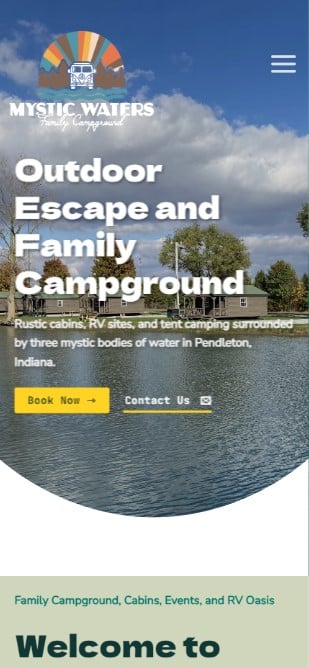 Screenshot of a mobile website for Mystic Waters Family Campground. The site, designed by Millworks Web Design & Graphics, features an outdoor photograph of a serene water body surrounded by trees and a cloudy blue sky. Text: "Outdoor Escape and Family Campground - Rustic cabins, RV sites, and tent camping surrounded by three mystic bodies of water in Pendleton, Indiana." Buttons for "Book Now