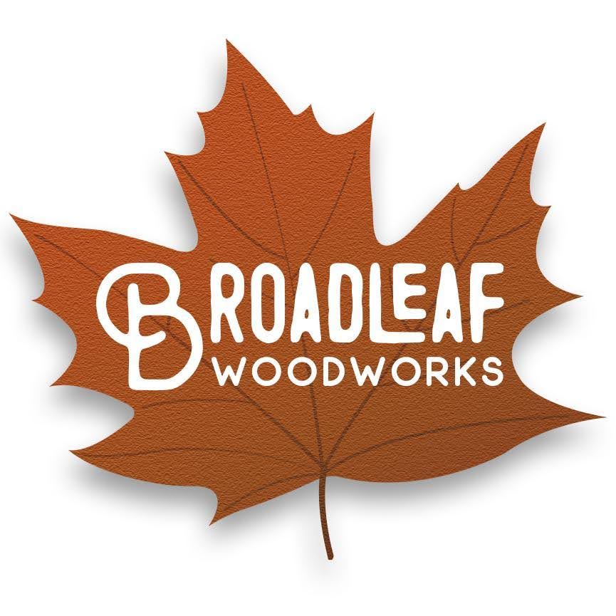 A logo featuring a large, orange maple leaf with text overlay saying "Broadleaf Woodworks" in white, stylized font. The word "Broadleaf" has a prominent capital "B" integrated into the design. The graphic design ensures the text contrasts against the textured leaf background.