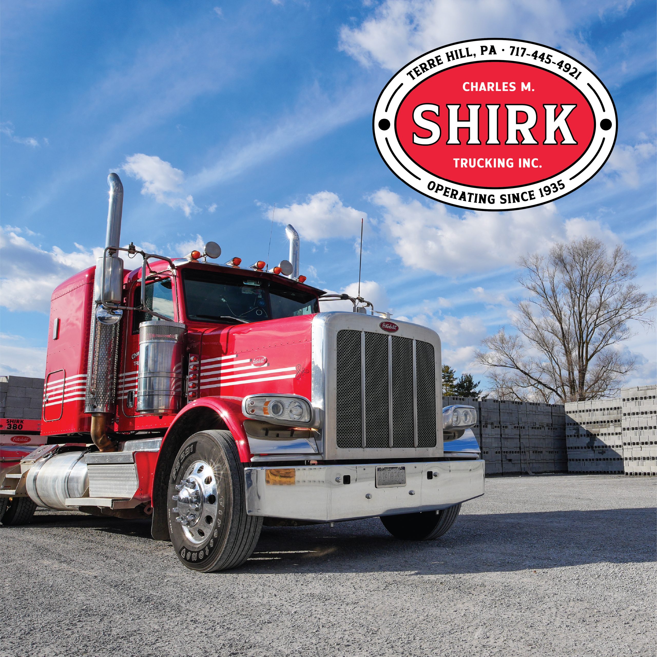 A bright red semi-truck is parked on gravel under a blue sky with scattered clouds. In the top right corner, the Shirk Trucking logo highlights that Shirk Trucking has proudly operated since 1935 in Terre Hill, PA.